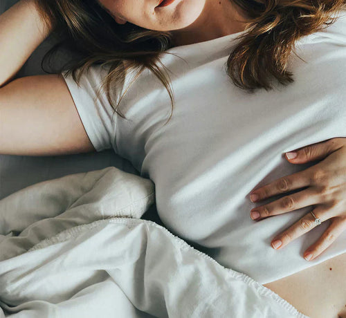 Jeune femme enceinte tenant tendrement son ventre au début de sa grossesse. - Mustela Belgium - 1