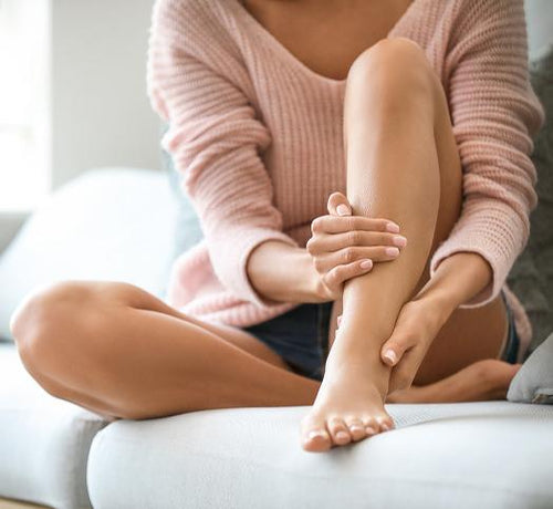 femme sur un canapé qui masse sa jambe - Mustela Belgium - 1