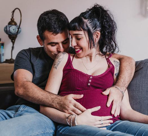 Un homme et une femme enceinte se tenant dans les bras - Mustela Belgium - 1