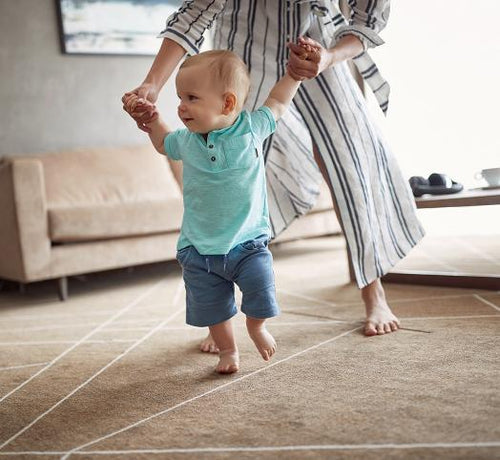 Enfant qui marche avec l'aide de sa maman - Mustela Belgium - 1