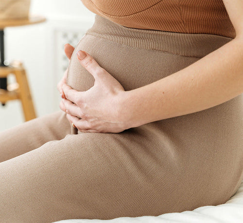 Une femme tient tendrement son ventre - Mustela Belgium - 1