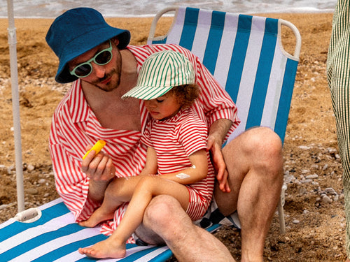 papa qui applique un stick solaire sur son enfant à la plage - Mustela Belgium - 5