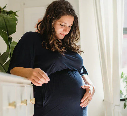 Femme enceinte de 9 mois tenant tendrement son ventre - Mustela Belgium - 1