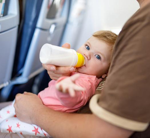 Bébé buvant un bibron dans un avion - Mustela Belgium - 1