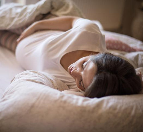 Femme enceinte allongée dans un lit  - Mustela Belgium - 1