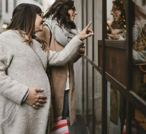 Deux femmes dont une enceinte regardant une vitrine d'un magasin - Mustela Belgium - 1