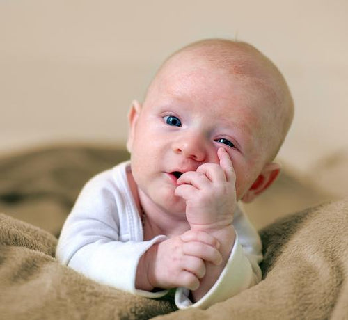 bébé qui touche son visage - Mustela Belgium - 1