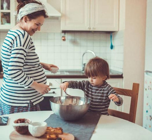 Femme enceinte cuisant avec son enfant dans une cuisine - Mustela Belgium - 1