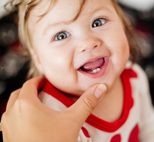 Enfant fille qui sourit avec deux dents de lait - Mustela Belgium - 1