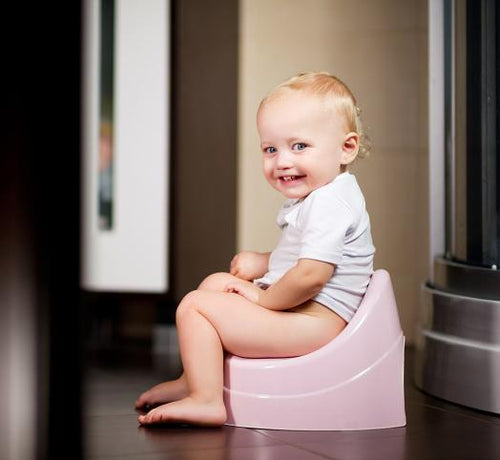 Enfant blond assis sur son pot rose - Mustela Belgium - 1