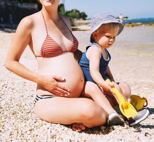 femme enceinte qui porte un enfant au soleil - Mustela Belgium - 1