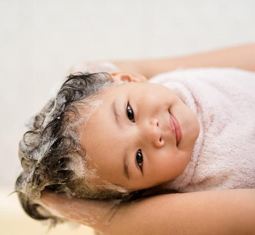 Visage enfant qui sourit avec les cheveux mouillés qui moussent - Mustela Belgium - 1