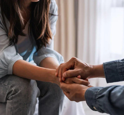 Un homme tient la main d'une femme pour la soutenir et l'accompagner.  - Mustela Belgium - 1