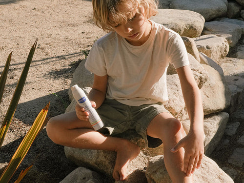 enfant s'appliquant de l'arnica en gelsur son bobo sur sa jambe - Mustela Belgium - 3