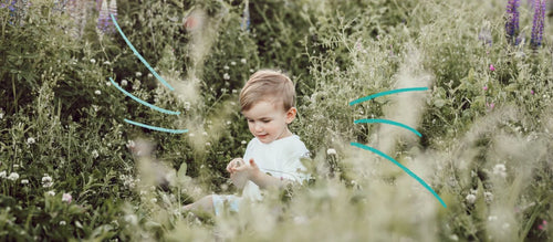 enfant-assis-dans-herbe - Mustela Belgium - 1