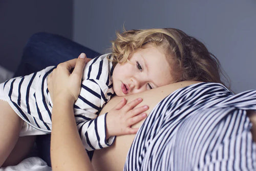 enfant-avec-tete-posee-ventre-femme-enceinte - Mustela Belgium - 1